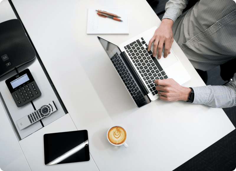 A person working on a laptop with a cup of coffee