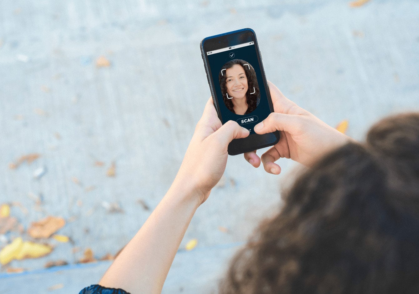 woman holding a smartphone and it requires face ID verification